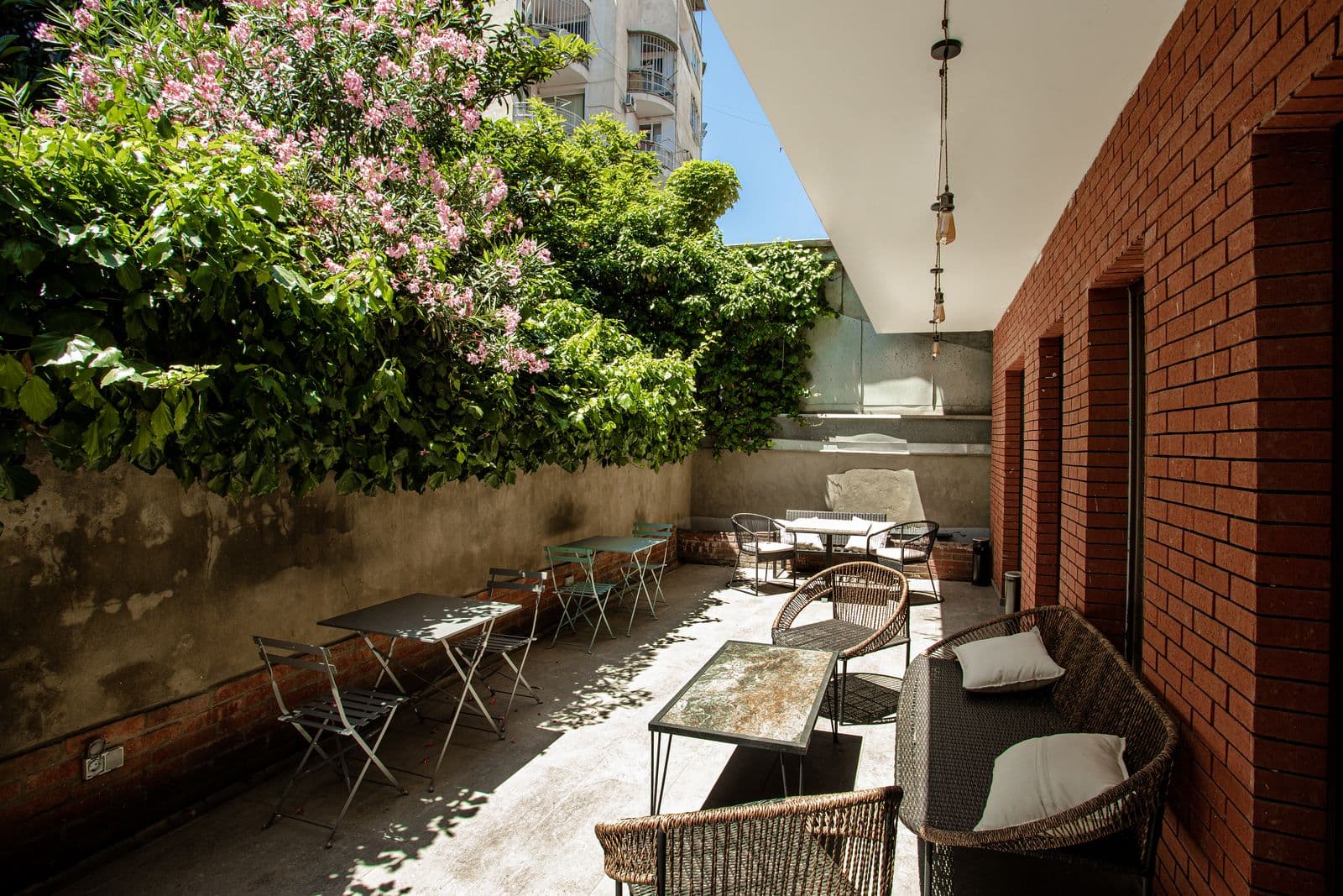 Terrace with wicker chairs under flowering trees